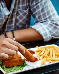 Wall Mural - man dipping chicken nugget into sweet chili sauce