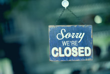 Blue Closed Sign In The Window Of A Shop Displaying The Message "Sorry We Are Closed"