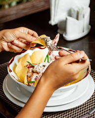 Wall Mural - woman eating meat salad in mayonnaise with chips