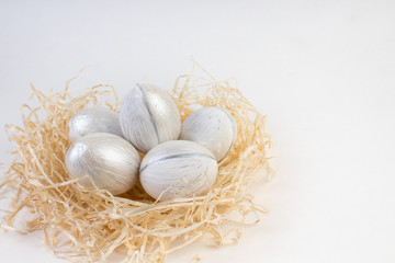 Happy Easter card. Colorful shiny eggs in a nest isolated on a white background. Copy space for text.