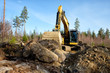 Yellow excavator building a road deep in the forest. Rusko, Finland.