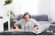 © Angelov - Man playing music with piano and laptop