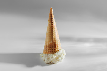 Ice cream cone fallen on white background.