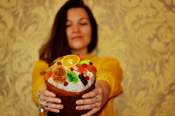 Easter. Beautiful brunette girl in a yellow sweater holds fruit Easter hands, with place for text, Easter day ... Decoration