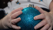 Midsection Of Baby Holding Christmas Bauble