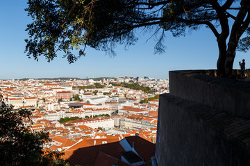 Wall Mural - Silhouette of a tourist at the Sao Jorge Castle's viewpoint and view of the historical old town in downtown Lisbon, Portugal, and beyond on a sunny day.