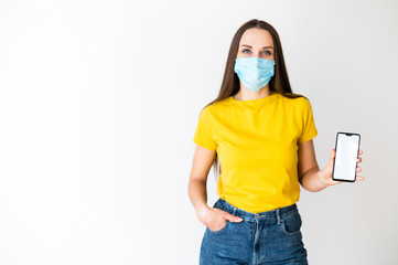 Wall Mural - Woman in medical mask shows her phone screen