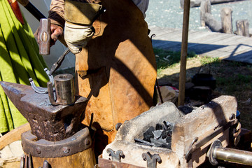 Wall Mural - Blacksmith makes a horseshoe, a master class in medieval craft, closeup hands