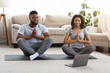© Prostock-studio - Quarantine trainings. Happy african american couple practicing yoga online with laptop