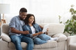 © Prostock-studio - Quarantine Leisure. Happy Black Couple Relaxing With Digital Tablet At Home