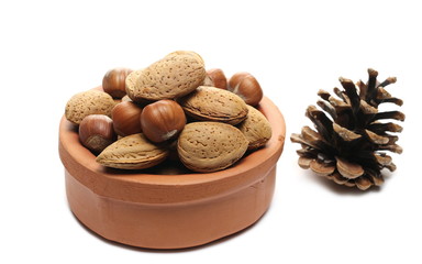 Wall Mural - Hazelnuts and almond in clay pot isolated on white background