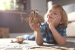 © New Africa - Little boy playing with cardboard helicopter on floor at home. Creative hobby
