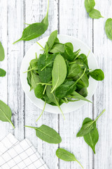 Wall Mural - Portion of fresh Spinach on a wooden table (close-up shot)