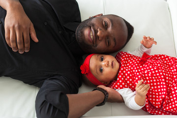 Young african american father holding with her baby girl