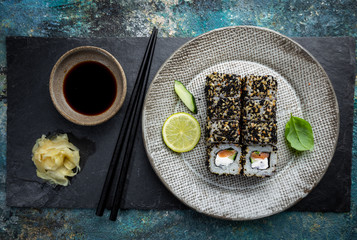 Wall Mural - Set of sushi and maki with soy sauce over blue stone background. Top view with copy space