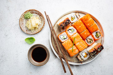 Wall Mural - Set of sushi and maki with soy sauce over white background. Top view with copy space