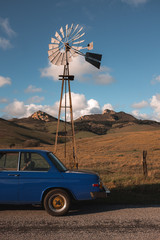 Wall Mural - vintage car in front of windmill on rural road