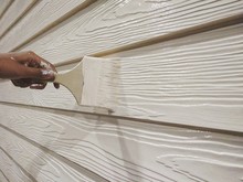 Cropped Hand Of Worker Painting Wooden Wall