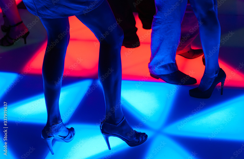 Taniec na podświetlanym parkiecie w nocnym klubie..Dance on the illuminated dance floor in the night club - obrazy, fototapety, plakaty 