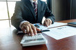 © tanasin - Businessman working with income statement document on the wood table.Business concept.