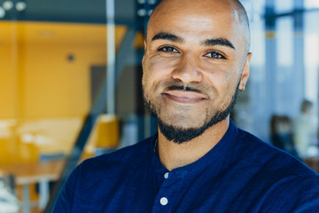 Handsome cheerful african american executive business man in office workspace. Concept of young people work in free schedule