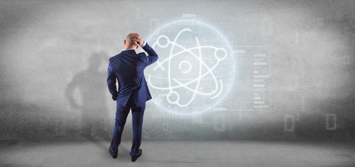 Wall Mural - Businessman holding an atom icon surrounded by data