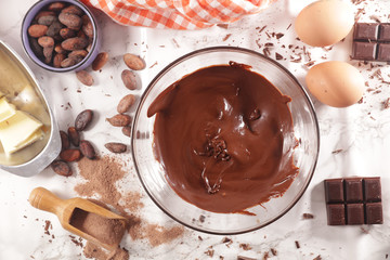 Wall Mural - melted chocolate in bowl with wooden spoon and ingredient