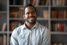 Happy Young African American Businessman Entrepreneur In Glasses, Head Shot Portrait. Smiling Millennial Biracial Man In Eyewear Looking At Camera, Posing For Photo In Modern Office, Library Or Home.
