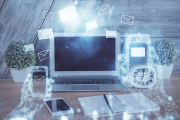 Desktop computer background in office and flying envelops hologram drawing. Multi exposure. Electronic mail concept.
