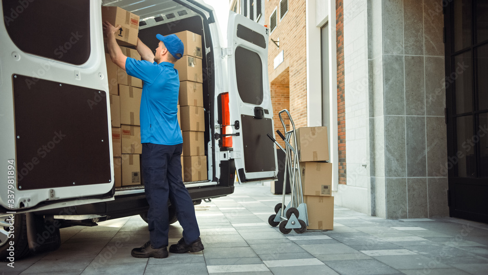 Delivery Man Uses Hand Truck Trolley Full of Cardboard Boxes and Packages, Loads Parcels into Truck / Van. Professional Courier / Loader helping you Move, Delivering Your Purchased Items Efficiently - obrazy, fototapety, plakaty 