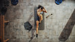 © Gorodenkoff - Top View Shot of Professional Female Bodybuilder Doing Bicycle Crunches while Lying on the Yoga Mat in the Hardcore Gym. Muscular and Athletic Beautiful Woman Muscle, Power and Cardio Workout.