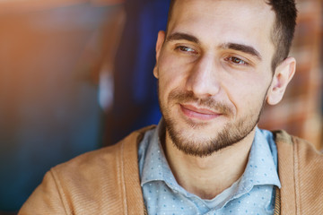 Portrait of a successful man who is in a cafe. The man smiles. Portrait close-up.