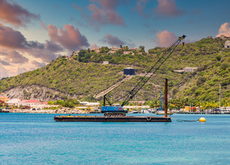 Wall Mural - A blue crane on a working barge over blue water in the harbor of Philipsburg in St Martin