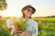 Outdoor Portrait Of Mature Happy Smiling Woman With Spring Flowers