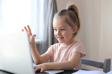 Little girl studing online with video call teacher. Distance learning in epidemic of Covid-19 coronavirus.