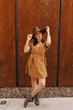 © diignat - Young fashion girl dressed in a summer dress with a wicker wide hat walks and poses in the old city. Street fashion portrait of young beautiful woman walking in the city