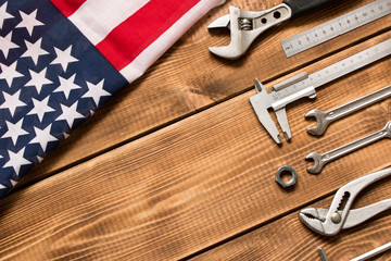 Wall Mural - Labor day. American flag and various tools on a wooden background. The concept of labor day. Empty space for text.