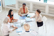 © Seventyfour - High angle view at diverse group of successful businesswomen discussing project while sitting at table during meeting in modern white office, copy space