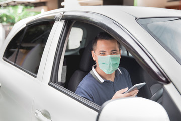 Wall Mural - young handsome male using mobile phone while driving his car