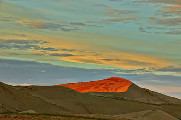 Wall Mural - Evening cloudy sky over the sand dunes.