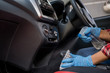 © Space_Cat - Cleansing car interior and spraying with disinfection liquid. Hands in rubber protective glove disinfecting automobile vehicle inside for protection from virus corona disease