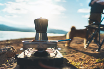 coffee maker outdoor, campsite morning picnic lifestyle, person cooking hot drink in nature camping, cooker prepare breakfast, tourism recreation