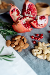 Wall Mural - Pomegranate fruit, walnuts, cashew nuts on the table - healthy food products