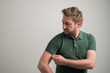 © Cipri Suciu  - Portrait of serious stylish attractive man with thick beard, dressed in casual green t shirt, arranging sleeve of t shirt