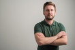 © Cipri Suciu  - Portrait of serious stylish attractive man with thick beard, dressed in casual green t shirt standing with arms crossed