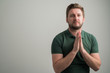 © Cipri Suciu  - Portrait of serious stylish attractive man with thick beard, dressed in casual green t shirt is praying