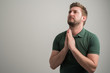© Cipri Suciu  - Portrait of serious stylish attractive man with thick beard, dressed in casual green t shirt is praying