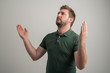 © Cipri Suciu  - Portrait of serious stylish attractive man with thick beard, dressed in casual green t shirt making winner gesture