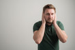 © Cipri Suciu  - Portrait of serious stylish attractive man with thick beard, dressed in casual green t shirt covering ears like deaf gesture