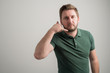© Cipri Suciu  - Portrait of serious stylish attractive man with thick beard, dressed in casual green t shirt showing calling or contact gesture